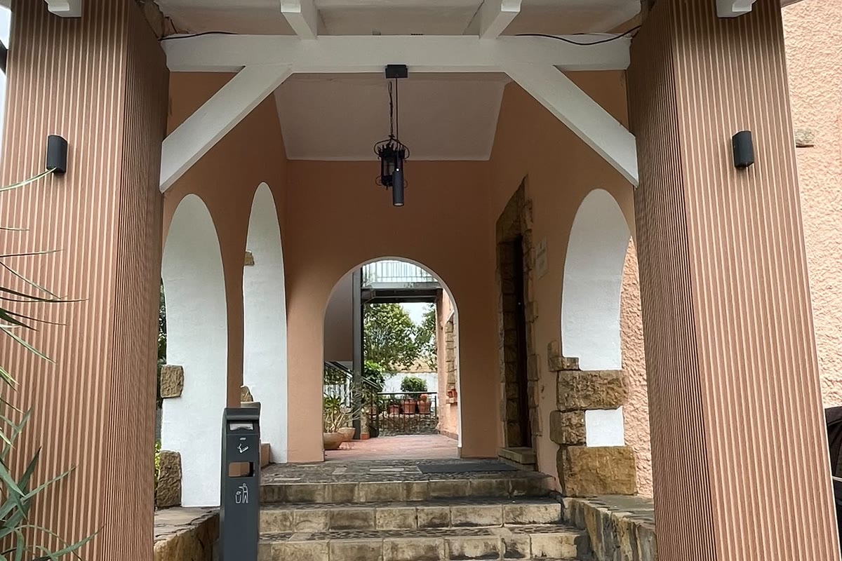 Pórtico de entrada con arcos encalados y escalones de canto rodado