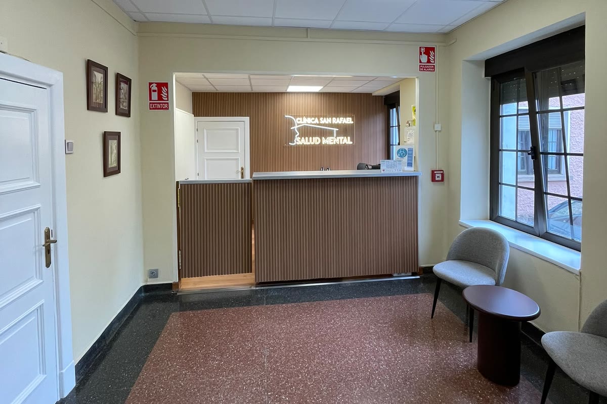 Mostrador de recepción de madera con el rótulo luminoso de la clínica